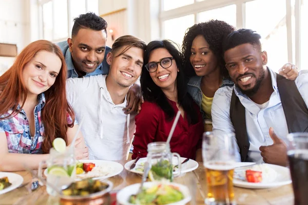 Amigos felices comiendo en el restaurante — Foto de Stock