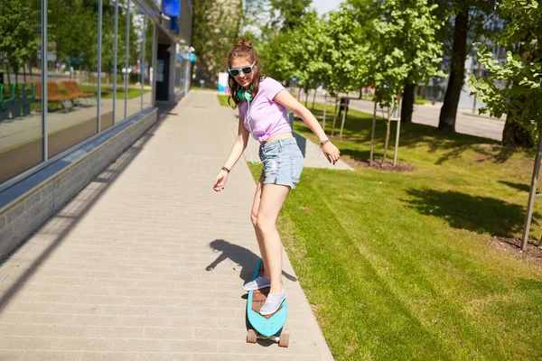 Menina adolescente feliz em tons de equitação no longboard — Fotografia de Stock