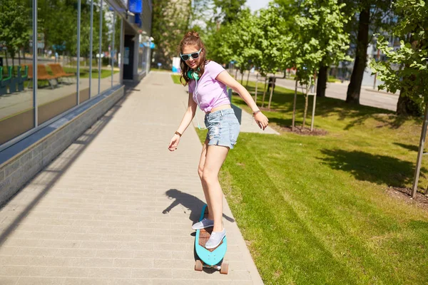 Feliz adolescente chica en tonos cabalgando en longboard —  Fotos de Stock