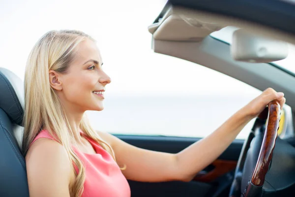 Feliz joven mujer conduciendo coche descapotable — Foto de Stock