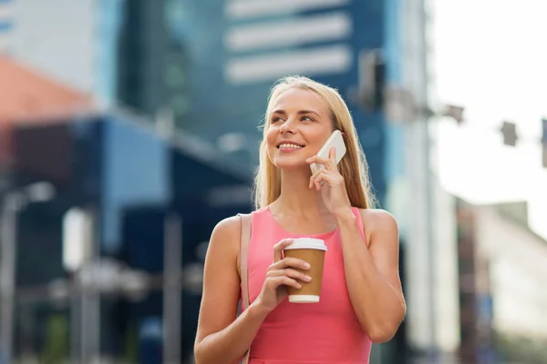 Жінка з викликом кави на смартфон у місті — стокове фото