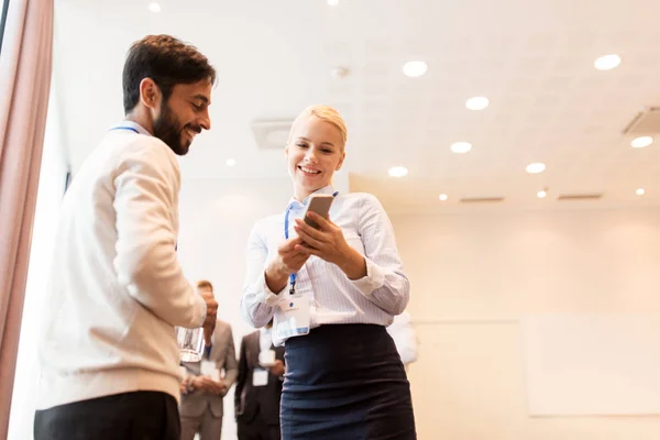 Par med smartphone på business konferensen — Stockfoto