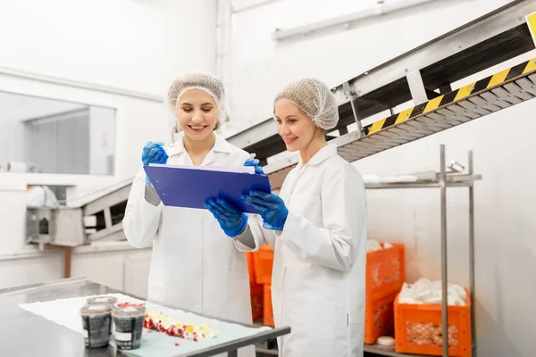 Mujeres tecnólogos degustación de helado en la fábrica — Foto de Stock