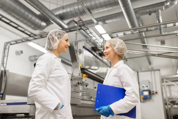 Mujeres felices tecnólogos en la fábrica de helados — Foto de Stock