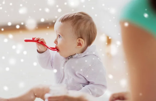 Madre y bebé con cuchara comiendo en casa — Foto de Stock