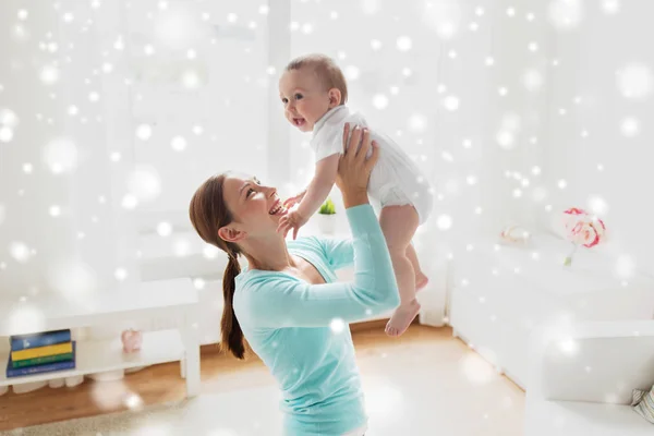 Boldog fiatal anya kisbabával otthon Stock Fotó