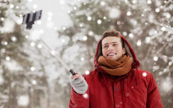 Счастливый мужчина делает селфи со смартфона зимой — стоковое фото