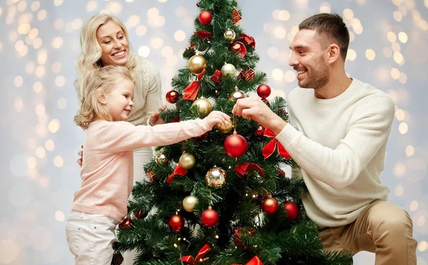 Happy family decorating christmas tree — Stock Photo, Image