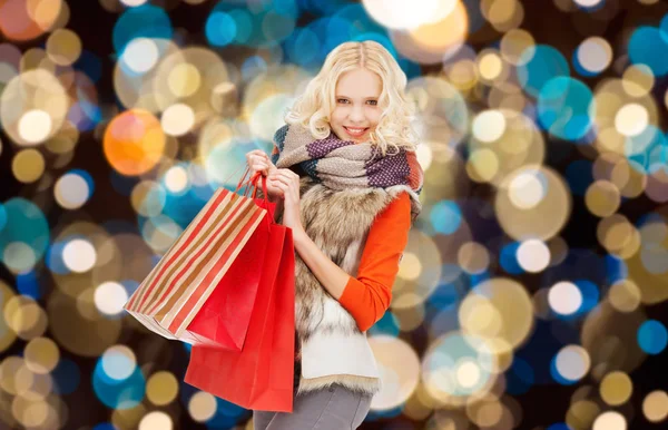 Jonge vrouw in winterkleren met shopping tassen — Stockfoto