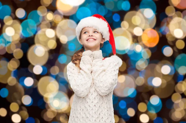 Dreaming girl in santa helper hat over lights — Stock Photo, Image