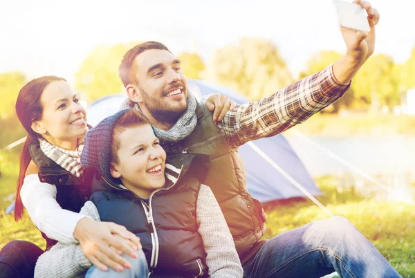 Family with smartphone taking selfie at campsite — Stock Photo, Image
