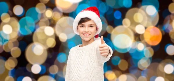 男孩在大拇指现身在圣诞节的圣诞老人的帽子 — 图库照片