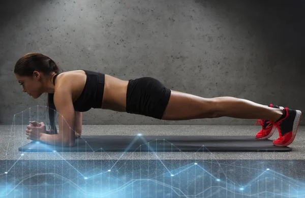 Kvinnan gör plankan träning på matta i gym — Stockfoto