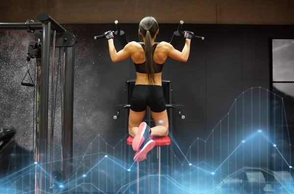 Mulher exercitando e fazendo pull-ups no ginásio — Fotografia de Stock