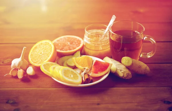 Chá de gengibre com mel, cítricos e alho em madeira — Fotografia de Stock