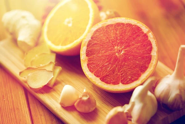 Grapefruit, ginger, garlic and orange on board — Stock Photo, Image