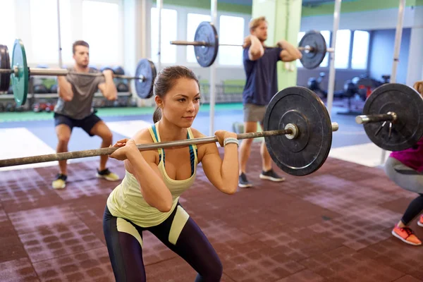 Grupo de personas entrenando con pesas en el gimnasio — Foto de Stock