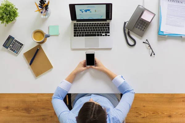 Zakenvrouw met laptop en smartphone op kantoor — Stockfoto