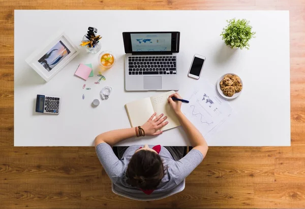 Vrouw met laptop schrijven naar notebook op kantoor — Stockfoto