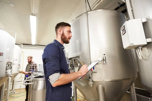 Hombres con portapapeles en cervecería artesanal o fábrica de cerveza —  Fotos de Stock