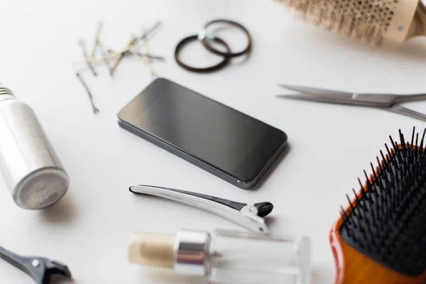 Смартфон, ножиці, пензлі та інші інструменти для волосся — стокове фото
