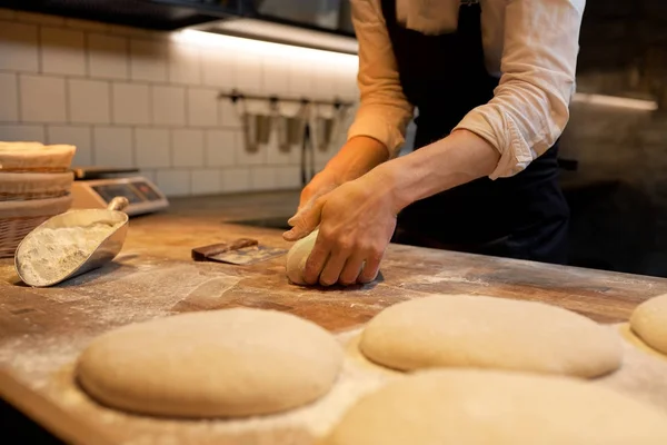 Шеф-повар или пекарь готовит тесто в пекарне — стоковое фото