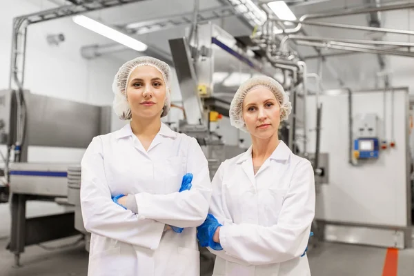 Mulheres felizes tecnólogos na fábrica de sorvete — Fotografia de Stock