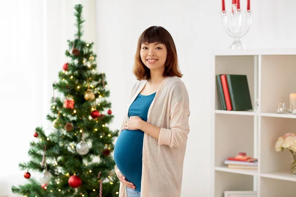 Glückliche Schwangere am heimischen Weihnachtsbaum — Stockfoto