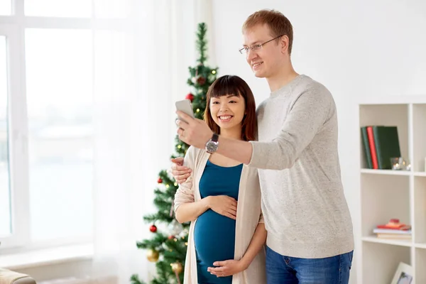 Lyckliga familjen paret tar selfie vid jul — Stockfoto