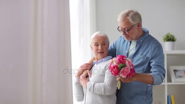 Feliz pareja de ancianos con ramo de flores en casa — Vídeos de Stock