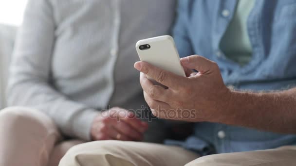 Glückliches Senioren-Paar mit Smartphone zu Hause — Stockvideo