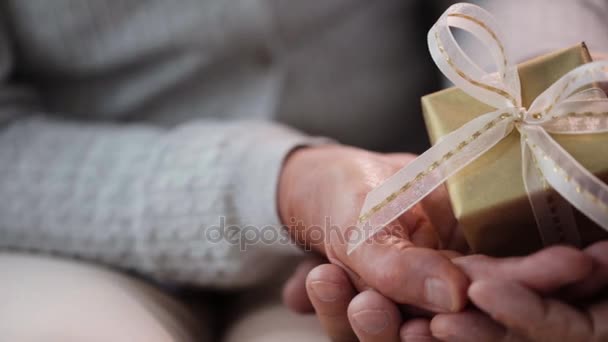 Пожилая пара рук с подарочной коробкой — стоковое видео
