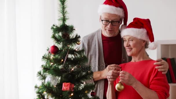 Feliz pareja de ancianos decorando árbol de Navidad — Vídeo de stock