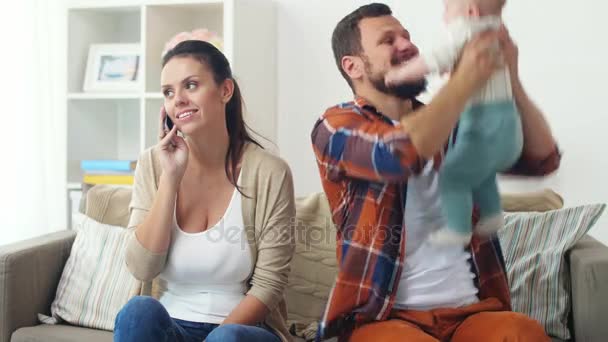 Father with baby and mother calling on smartphone — Stock Video