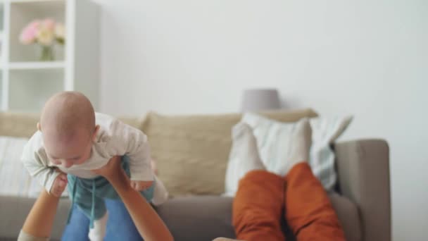 Mutlu anne ve babası evde bebekle oynarken — Stok video