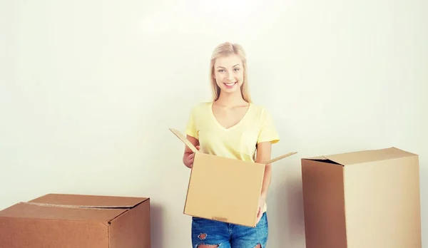 Giovane donna sorridente con scatola di cartone a casa — Foto Stock