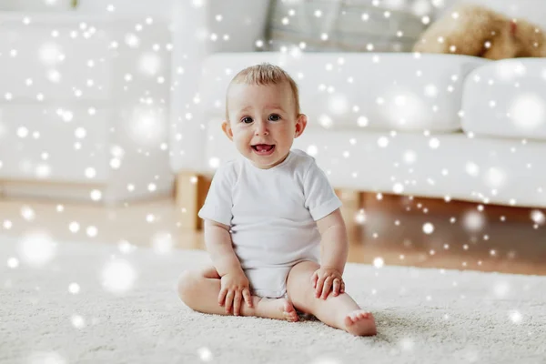 Glad liten pojke eller flicka sitter på golvet hemma — Stockfoto