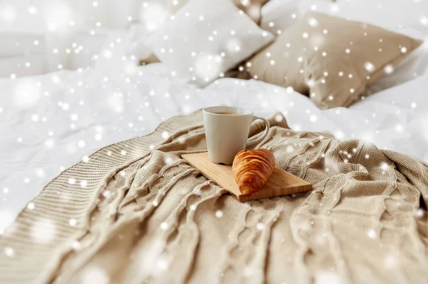 Чашка кави і круасан на плоскій в ліжку вдома — стокове фото