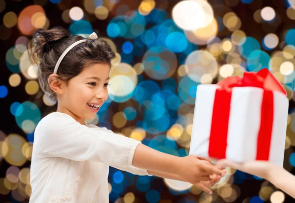 Lächelndes kleines Mädchen, das Geschenke gibt oder entgegennimmt — Stockfoto
