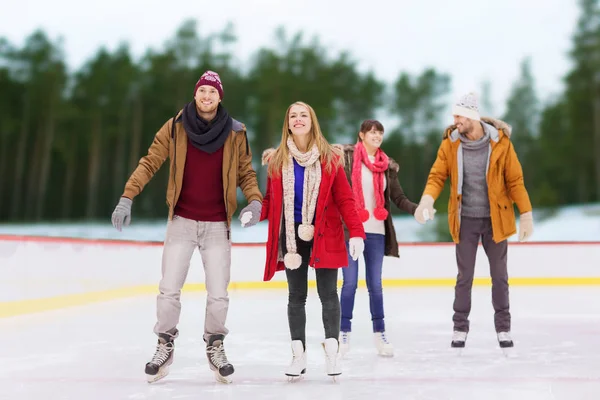 Friends holding hands on outdoor skating rink — Stock Photo, Image