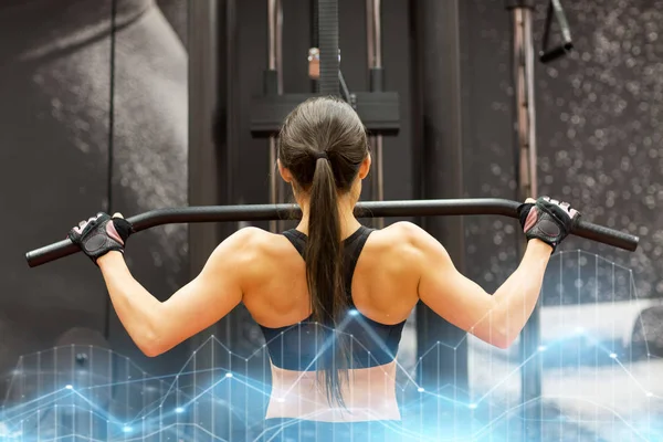 Kvinna som flexar muskler på kabel maskin i gymmet — Stockfoto