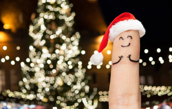 Finger med smiley i Tomtemössa på julgran — Stockfoto