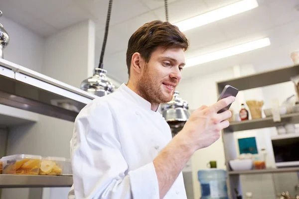 Cuoco cuoco con smartphone al ristorante cucina — Foto Stock