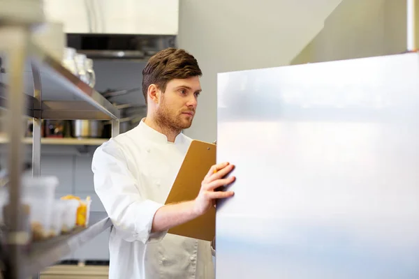 Chef con portapapeles haciendo inventario en la cocina — Foto de Stock