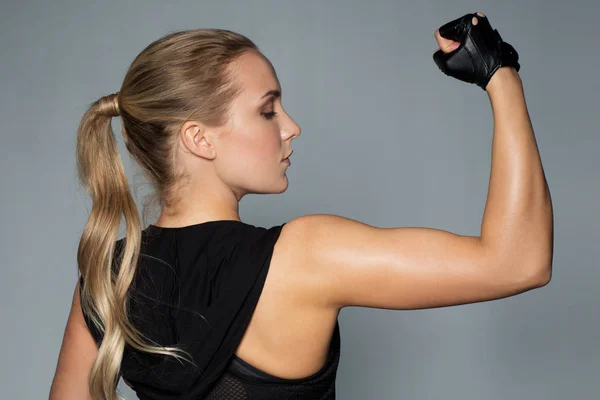 Primer plano de la mujer posando y mostrando bíceps en el gimnasio —  Fotos de Stock