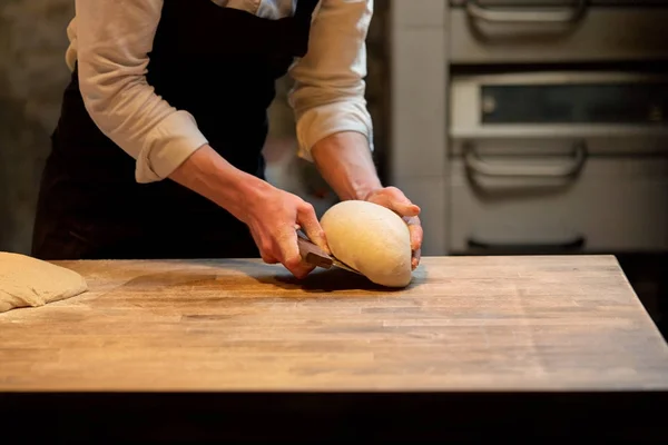 Pâte de portionnement boulanger avec coupe-banc à la boulangerie — Photo