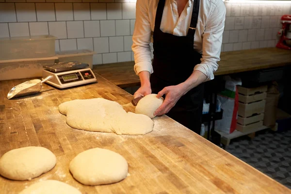 Masa de porción de panadero con cortador de banco en la panadería —  Fotos de Stock