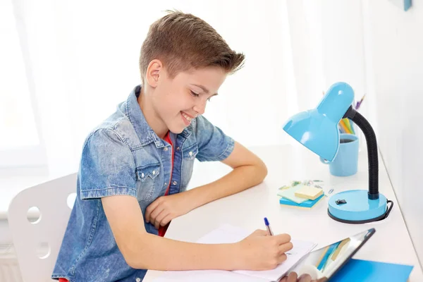 Student szczęśliwy chłopiec piśmie do notebooka w domu — Zdjęcie stockowe