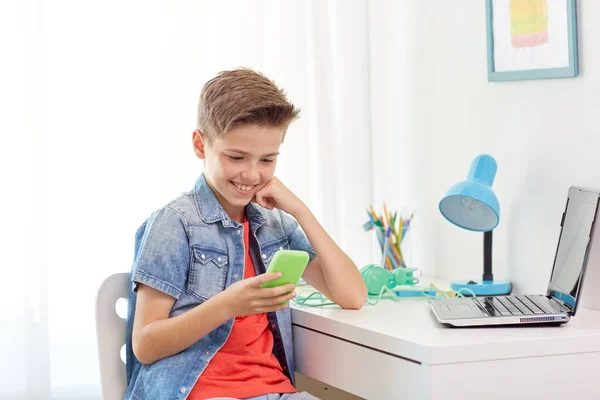 Щасливий хлопчик зі смартфоном і ноутбуком вдома — стокове фото