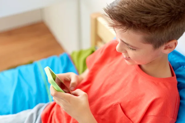 Nahaufnahme eines glücklichen Jungen mit Smartphone zu Hause — Stockfoto